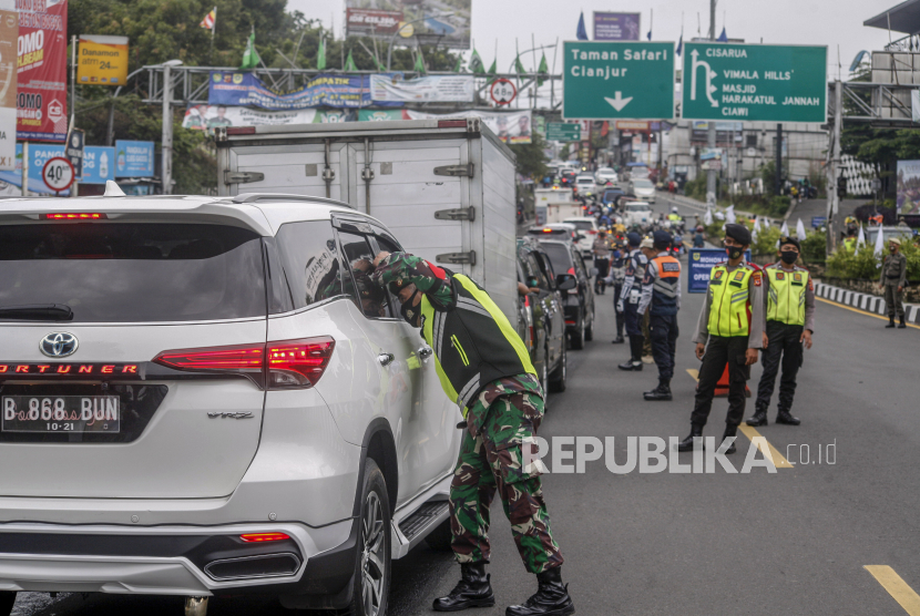 Sejumlah petugas gabungan melakukan pembatasan kendaraan di Jalan Raya Puncak, Gadog, Kabupaten Bogor, Jawa Barat.