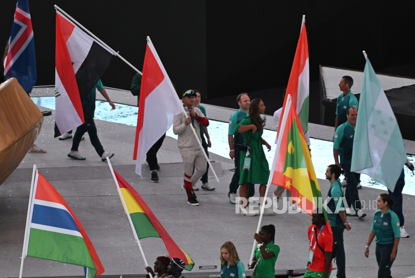 Lifter Indonesia Rizky Juniansyah (tengah) membawa bendera Merah Putih saat mengikuti penutupan Olimpiade Paris 2024 di Stadion Stade de France, Paris, Prancis, Ahad (11/8/2024). Pada Olimpiade Paris 2024, Indonesia berada di urutan 39 dengan perolehan medali 2 emas dan 1 perunggu, sementara olimpiade selanjutnya akan dilakasanakan di Los Angeles, Amerika Serikat pada 2028. 