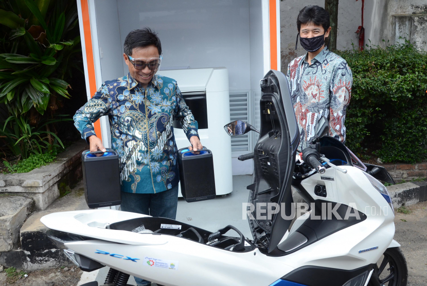 Dirut PT Pos Indonesia Faizal Rochmad Djoemadi (kiri) membawa dua baterai motor listrik di BEX,  Kantor Pos, Jalan Asia Afrika, Kota Bandung, Jumat (5/2/2021). 