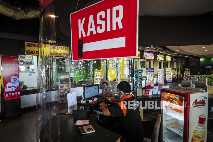 Pekerja melayani pengunjung bertransaksi di kasir yang diberi pembatas plastik pada salah satu restoran di Bekasi, Jawa Barat (ilustrasi)