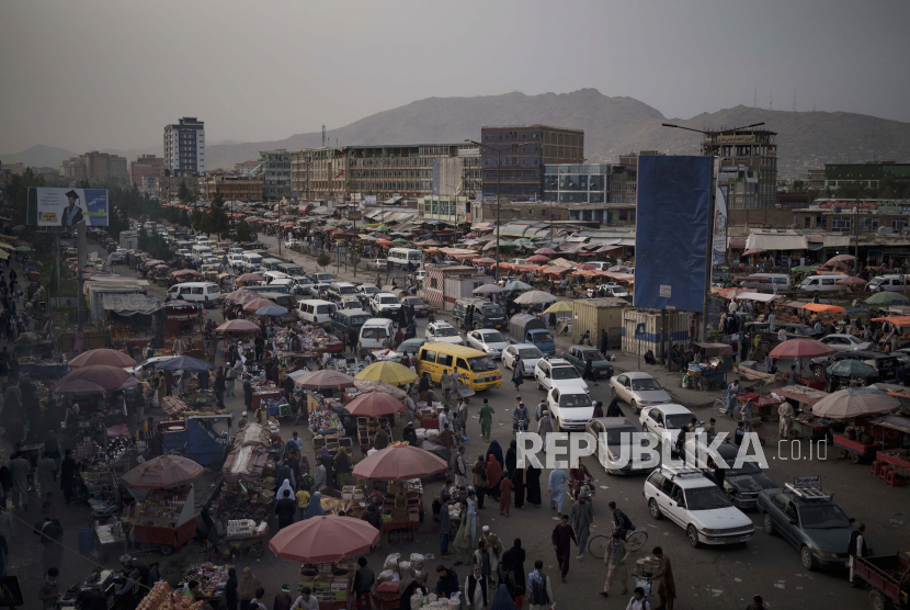 Mobil menunggu di lalu lintas saat warga Afghanistan berbelanja di pasar lokal di Kabul, Afghanistan, Sabtu, 11 September 2021.