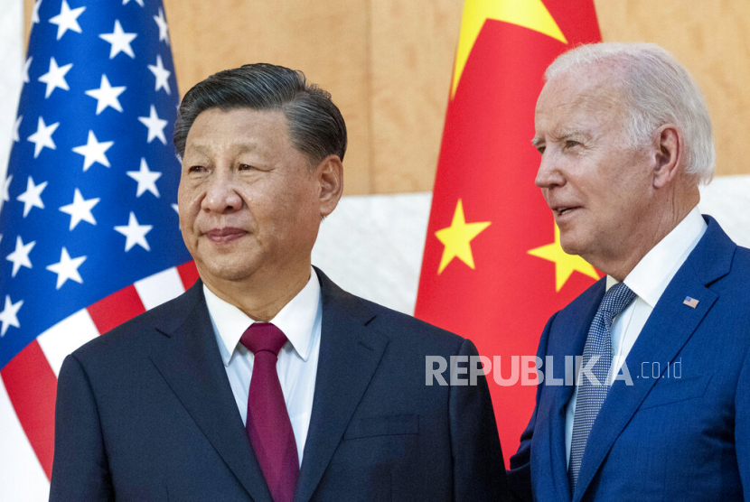 FILE - U.S. President Joe Biden, right, stands with Chinese President Xi Jinping before a meeting on the sidelines of the G20 summit meeting on Nov. 14, 2022, in Bali, Indonesia. Xi accused Washington on Monday, March 6, 2023, trying to isolate his country and hold back its development. That reflects the ruling Communist Party