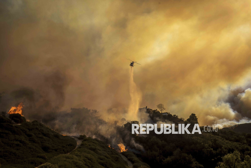 Helikopter menyiramkan air dalam upaya memadamkan kebakaran besar yang melanda kawasan Pacific Palisades, Los Angeles, 