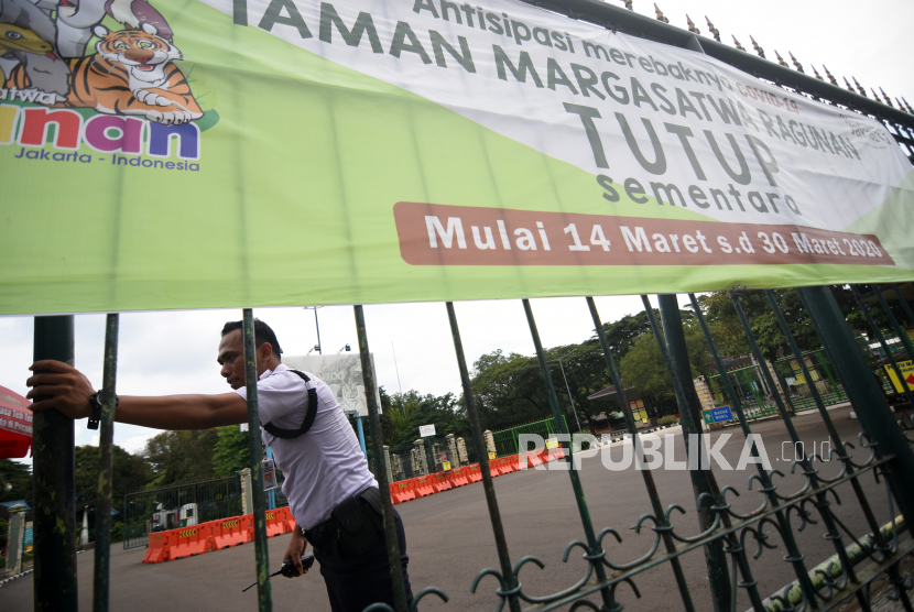 Petugas keamanan berjaga di depan pintu masuk Taman Margasatwa Ragunan yang ditutup operasionalnya di Jakarta, Sabtu (21/3/2020).  Kawasan wisata tersebut ditutup oleh Pemprov DKI Jakarta bersama 16 kawasan wisata lainnya sejak 14 Maret sampai 30 Maret 2020 sebagai antisipasi penyebaran wabah COVID-19. 