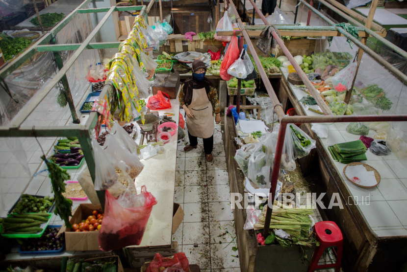 Pedagang melayani pembeli di balik tirai plastik di Pasar Bandeng, Kota Tangerang, Banten, Selasa (2/6). Pengelola pasar Bandeng mewajibkan pedagang untuk memasang tirai plastik sebagai antisipasi penyeberan COVID-19