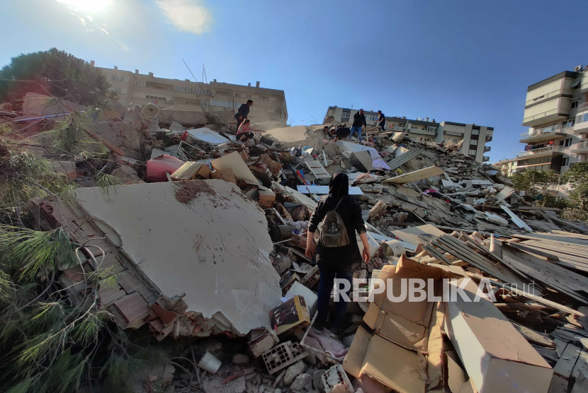 Orang-orang di gedung yang runtuh setelah gempa berkekuatan 7,0 di Laut Aegea di Izmir, Turki, 30 Oktober 2020. Menurut laporan media Turki, puluhan bangunan hancur dalam gempa bumi.
