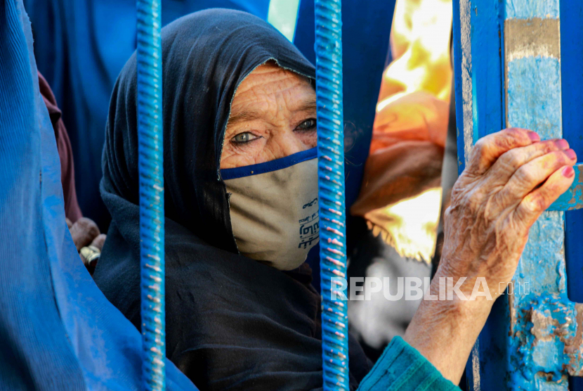 Seorang wanita pengungsi internal Afghanistan menunggu untuk menerima bantuan makanan 