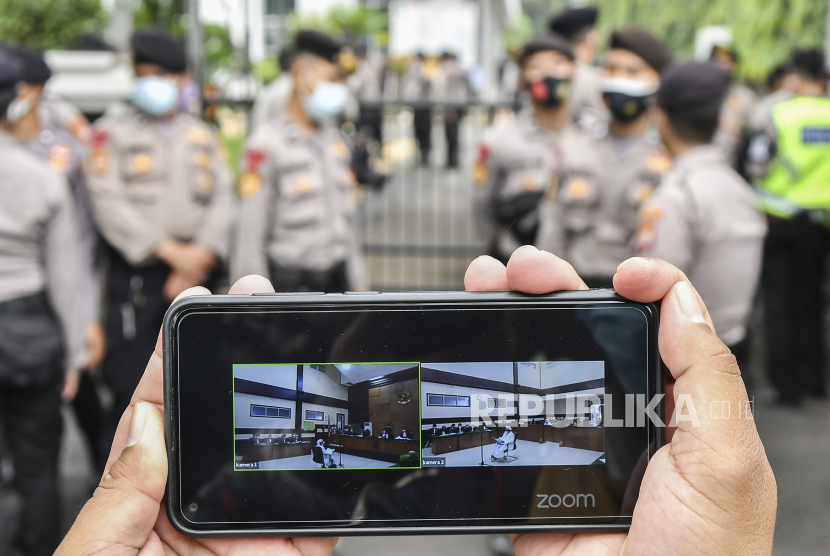Layar telepon pintar menampilkan suasana sidang kasus pelanggaran protokol kesehatan dengan terdakwa Rizieq Shihab yang digelar secara virtual di Pengadilan Negeri (PN) Jakarta Timur, Jakarta, Selasa (30/3). Sidang tersebut beragendakan mendengarkan pendapat jaksa penuntut umum atas eksepsi terdakwa.