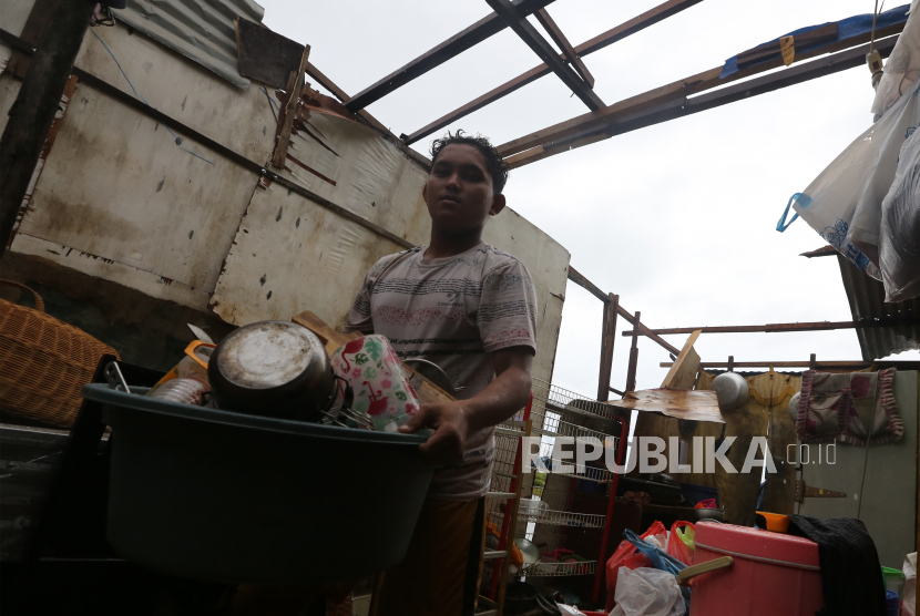 Warga membawa barang rumah tangga untuk diungsikan setelah atap rumahnya rusak akibat diterjang angin kencang  (ilustrasi)