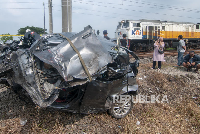 Warga melihat mobil yang tertabrak kereta api di Wonosari, Klaten, Jawa Tengah, Rabu (1/5/2024). 