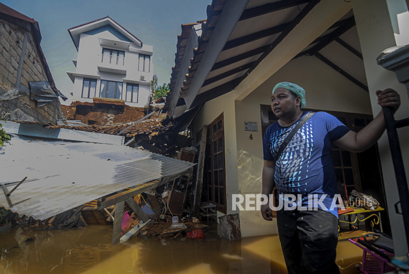 Warga beraktivitas saat terjadi banjir yang diakibatkan longsor di kawasan Ciganjur, Jakarta, Ahad ( 11/10). Hujan dengan intensitas lebat pada Sabtu (10/11), membuat tembok pembatas kali di perumahan roboh akibat longsor hingga menutupi aliran Kali Anak Setu yang membuat pemukiman warga terendam banjir. Tercatat terdapat dua korban luka-luka dan satu orang meninggal dunia akibat peristiwa tersebut. Republika/Putra M. Akbar