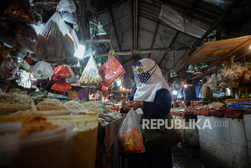 Warga menggunakan pelindung wajah saat belanja di pasar tradisional Pasar Minggu, Jakarta, Kamis (17/9). Badan Kebijakan Fiskal Kementerian Keuangan (BKF Kemenkeu) menyebutkan, laju inflasi akan sangat bergantung pada tren pertumbuhan ekonomi. 