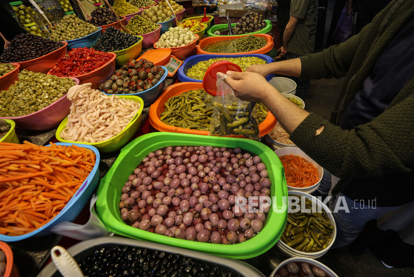 Pedagang Palestina menjual zaitun dan acar di pasar sebelum bulan suci Ramadhan di Kota Gaza, (21/4/2020). Yordania menangguhkan sementara izin impor minyak zaitun dari Palestina. 