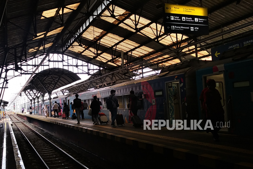 Penumpang kereta api jarak jauh naik ke atas kereta di Stasiun Yogyakarta.