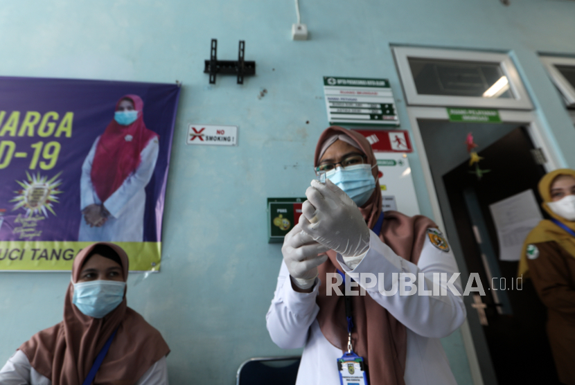 Seorang petugas kesehatan menyiapkan dosis vaksin.