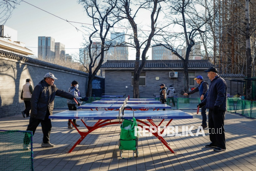 Pria lanjut usia (depan) bermain tenis meja di sebuah taman di Beijing, Cina, 22 Januari 2024. T