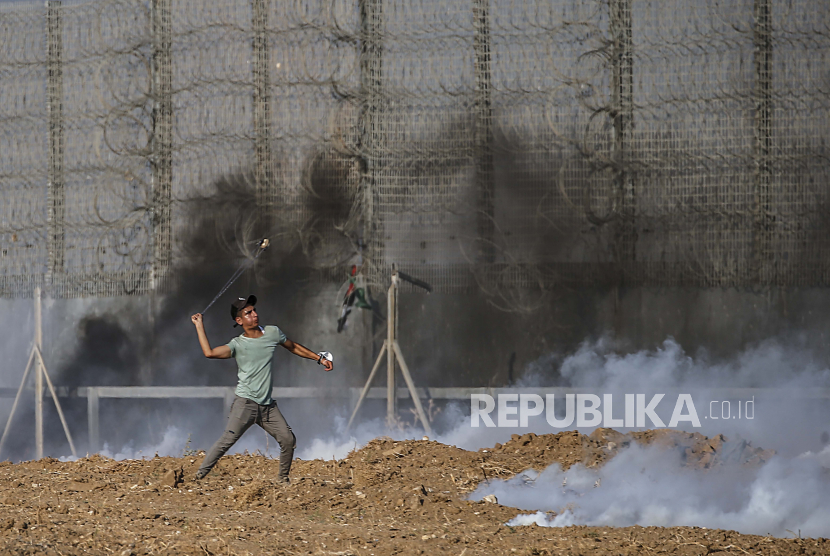 Pengunjuk rasa Palestina melempari tentara Israel dengan batu selama bentrokan di dekat perbatasan antara Israel dan Jalur Gaza, di Jalur Gaza timur, 21 Agustus 2021. Empat puluh satu warga Palestina dan satu tentara Israel terluka dalam bentrokan di dekat perbatasan timur Kota Gaza.
