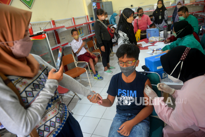Orang tua mendampingi siswa saat vaksinasi Covid-19 susulan di SD Muhammadiyah Sagan, Yogyakarta, Selasa (25/1/2022). Komisi Nasional KIPI menerima laporan KIPI anak dan remaja, namun jumlahnya tak sebanyak orang dewasa.