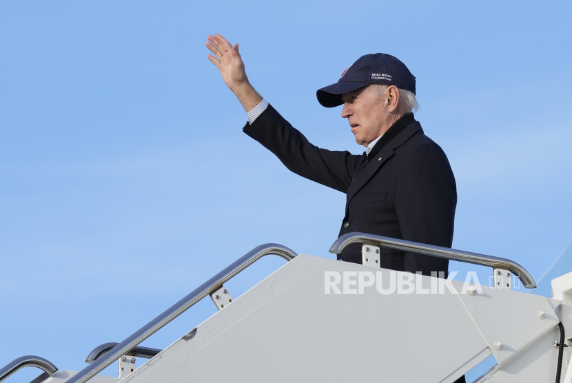 Presiden Joe Biden melambaikan tangan saat menaiki Air Force One di Moffett Federal Airfield di Mountain View, California, setelah mengalami kerusakan akibat badai pada Kamis, 19 Januari 2023.