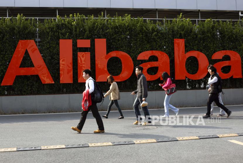 Orang-orang berjalan melewati tanda di kampus kantor pusat Alibaba Group di Hangzhou, provinsi Zhejiang, Cina, 17 Maret 2014 (diterbitkan ulang 01 Januari 2021). Alibaba akan mempublikasikan hasil kuartal keempat 2020 mereka pada 02 Januari 2021.