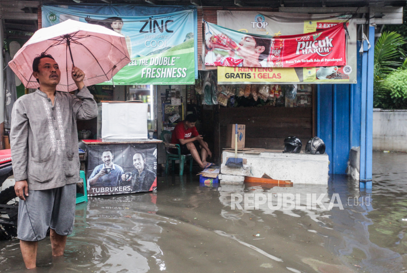 Pedagang menjaga warungnya saat terjadi banjir di Pondok Karya, Mampang, Jakarta Selatan, Kamis (4/1/2024). Banjir setinggi 80 sentimeter tersebut diakibatkan hujan dengan intensitas tinggi di wilayah Jakarta Selatan hingga membuat aliran air dari Kali Krukut meluap.