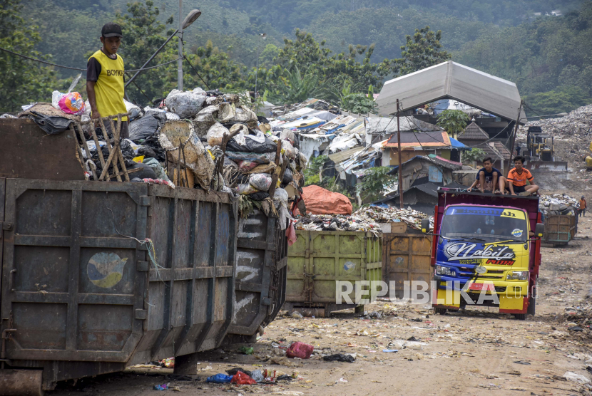 Warga memilah sampah di atas bak sampah yang terparkir di TPA Sarimukti, Cipatat, Kabupaten Bandung Barat, Ahad (7/11). Operasional alat berat untuk kegiatan sanitary landfil (menumpuk, memadatkan dan menimbun sampah dengan tanah) di tempat pembuangan akhir (TPA) Sarimukti terganggu akibat krisis pasokan bahan bakar minyak (BBM) sejak Jumat (5/11). Hal tersebut mengakibatkan terhambatnya proses bongkar muat sampah dan pengangkutan sampah di wilayah Bandung Raya. Foto: Republika/Abdan Syakura