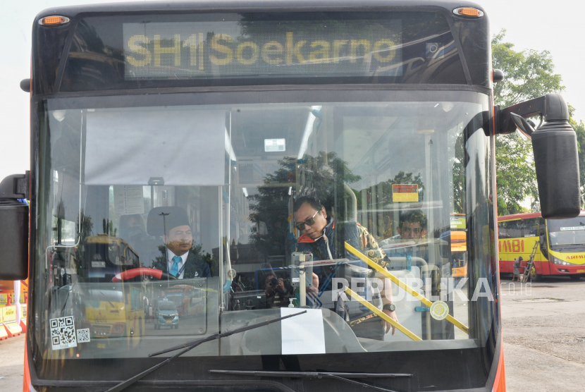 Penumpang menaiki bus Transjakarta rute Kalideres -Bandara Soekarno Hatta di Terminal Kalideres, Jakarta Barat, Jumat (7/7/2023).