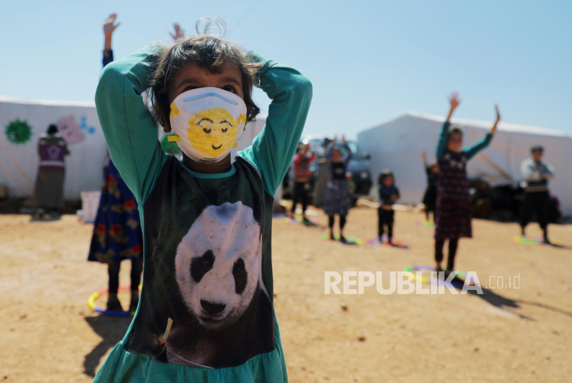 Bocah pengungsi di Idlib Suriah mengenakan masker bergambarkan karakter smiley.