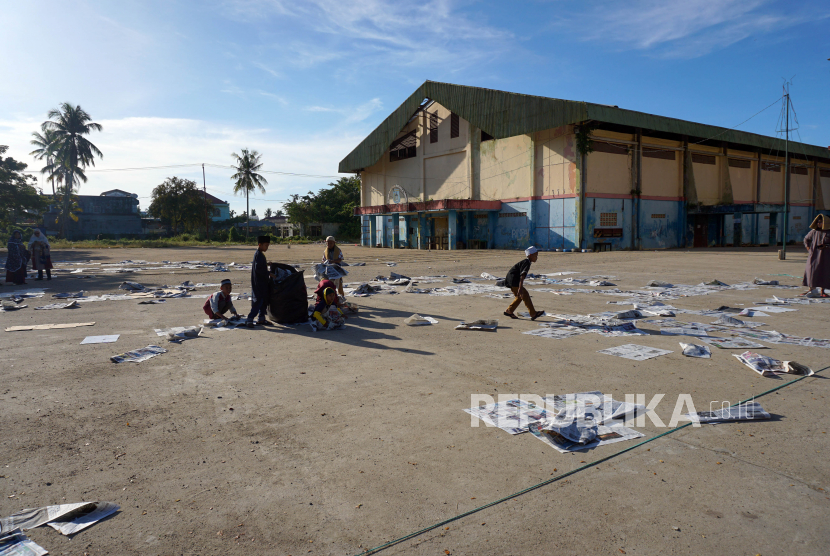 Sejumlah anak memungut koran koran bekas yang digunakan untuk alas saat shalat Id di halaman Gedung Olah Raga (GOR) Pancasila Kota Sorong, Papua Barat, Senin (2/5/2022).