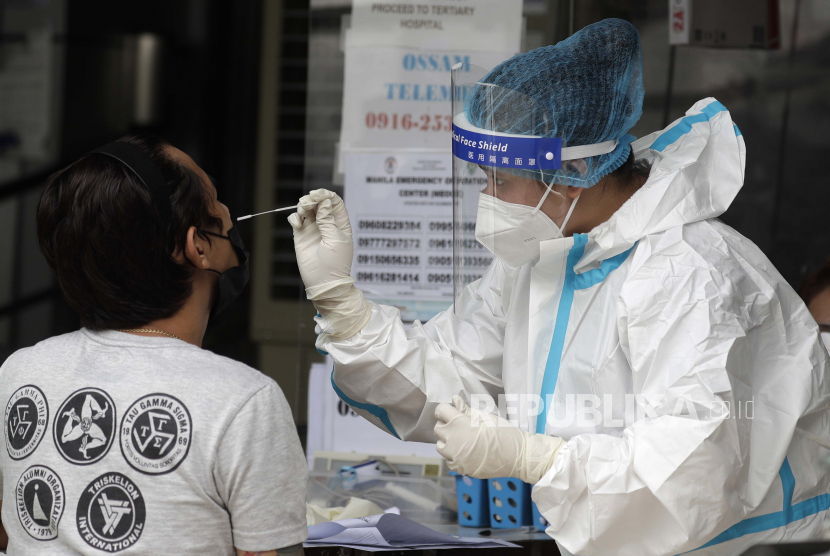Seorang petugas kesehatan melakukan tes COVID-19 pada seorang pria di sebuah rumah sakit di Manila, Filipina pada hari Senin, 26 April 2021.
