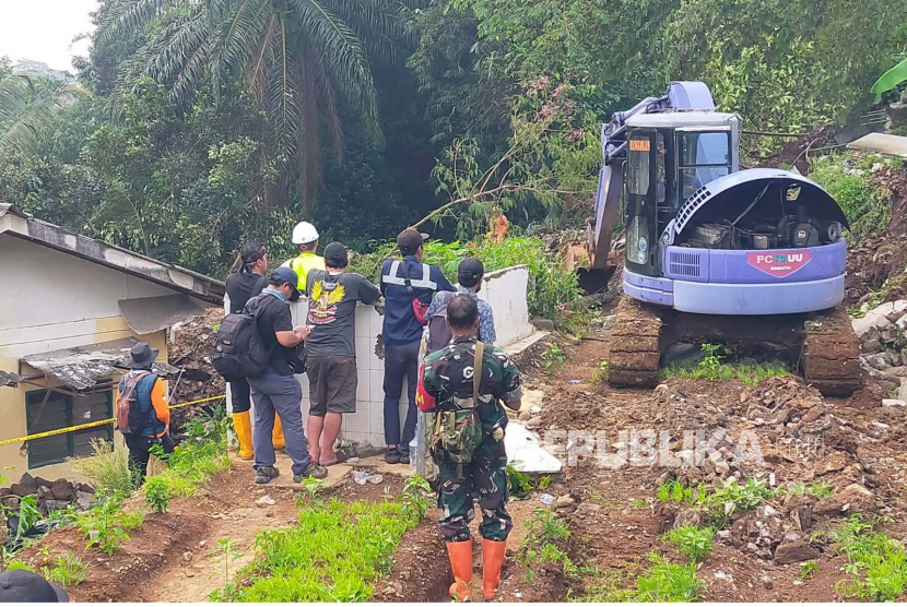 Alat berat ekskavator diturunkan untuk membantu evakuasi korban tertimbun longsor di Kampung Sirnasari, Kelurahan Empang, Kecamatan Bogor Selatan, Kota Bogor. 