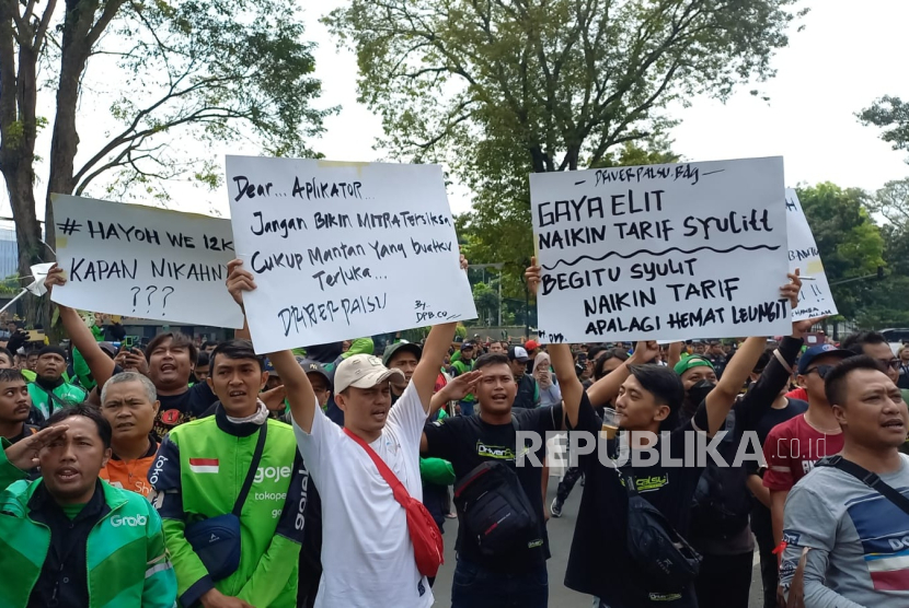 Pengemudi ojek online (ojol) dan taksi online melakukan aksi demonstrasi di depan Gedung Sate, Kota Bandung, Selasa (25/6/2024). Mereka menolak kebijakan tarif murah dan meminta agar pemerintah mendorong perusahaan aplikasi menaikkan tarif bagi ojol.