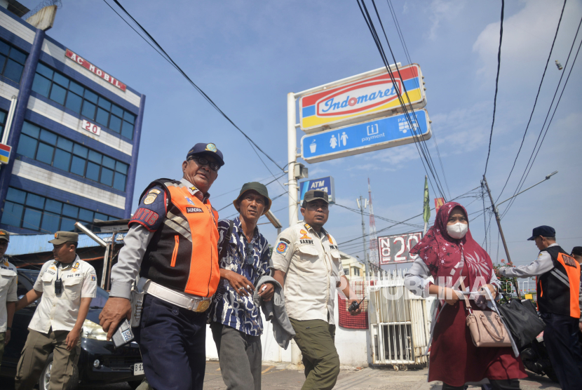 Tim gabungan saat melakukan penertiban juru parkir liar yang berada di minimarket kawasan Bungur, Senen, Jakarta Pusat, Rabu (15/5/2024). 