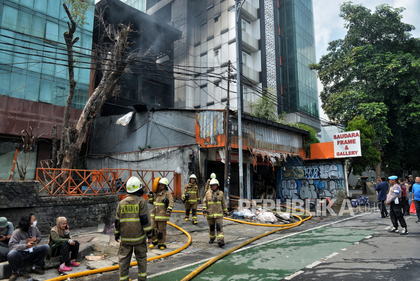 Petugas Gulkarmat DKI Jakarta melakukan pendinginan sisa kebakaran di Jalan Mampang Prapatan. Tim Puslabfor Polri melakukan olah TKP di lokasi kebakaran Mampang tewaskan 7 orang.