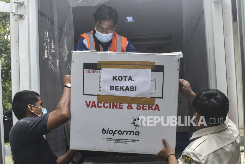 Sejumlah petugas memindahkan vaksin COVID-19 Sinovac yang didatangkan dari Bandung setibanya di gudang Instalasi Farmasi, Bekasi, Jawa Barat, Selasa (12/1/2021). Sebanyak 14.060 vial vaksin Sinovac pada tahap pertama diprioritaskan untuk tenaga kesehatan di Kota Bekasi. 