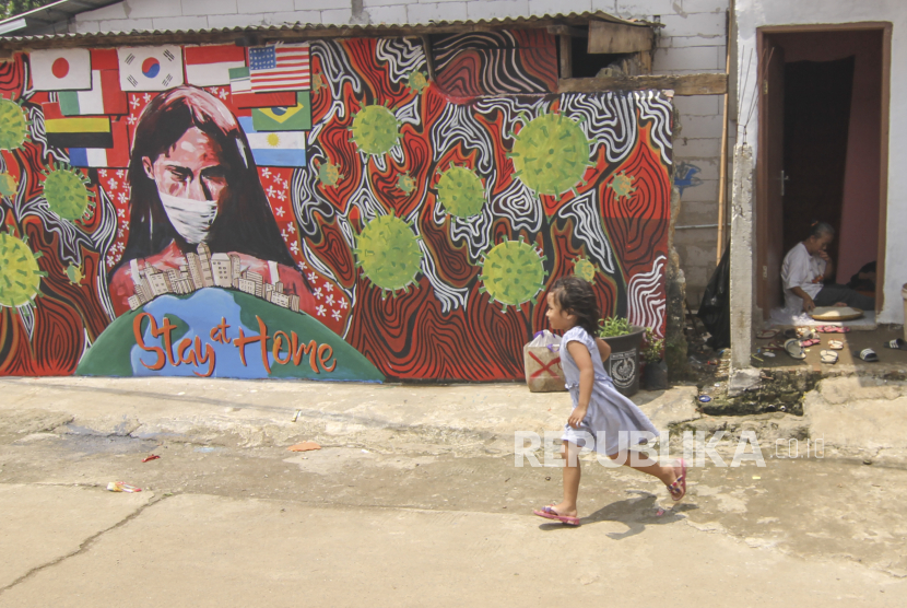 seorang anak melintas di depan mural bertuliskan Stay At Home di Cipayung, Depok, Jawa Barat, Selasa (14/4/2020). Pemerintah Kota Depok akan menerapkan Pembatasan Sosial Berskala Besar (PSBB) mulai Rabu (15/4) sebagai upaya memutus rantai penyebaran virus corona COVID-19