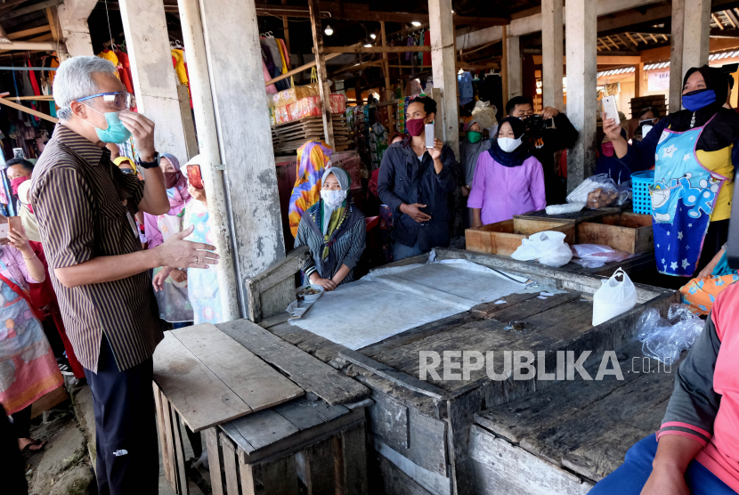 Gubernur Jawa Tengah Ganjar Pranowo (kiri) berdialog dengan sejumlah pedagang saat mnegunjungi pasar Kandangan, Temanggung, Jawa Tengah, Selasa (16/6/2020). Dalam kunjungannya ke sejumlah pasar tradisional di kabupaten Temanggung Ganjar Pranowo menyampaikan sosialisasi pentingnya protokol kesehatan dalam mencegah penyebaran COVID-19 yang angkanya cukup tinggi di wilayah Jawa Tengah