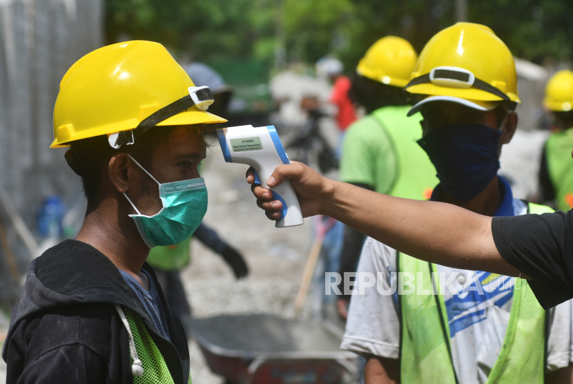 Warga peserta Padat Karya Tunai (PKT) dari kelompok swadaya masyarakat (KSM) Morambanga diukur suhu tubuhnya sebelum memulai pengerjaan pengecoran jalan program Kota Tanpa Kumuh (Kotaku) di Kelurahan Layana Indah di Palu, Sulawesi Tengah, Sabtu (6/6/2020).Pelaksanaan pekerjaan dengan pola padat karya tersebut bertujuan untuk membuka lapangan pekerjaan dan memberikan penghasilan sementara kepada masyarakat akibat pandemi COVID-19 dan pada tahun ini pemerintah mengalokasikan anggaran sebesar Rp