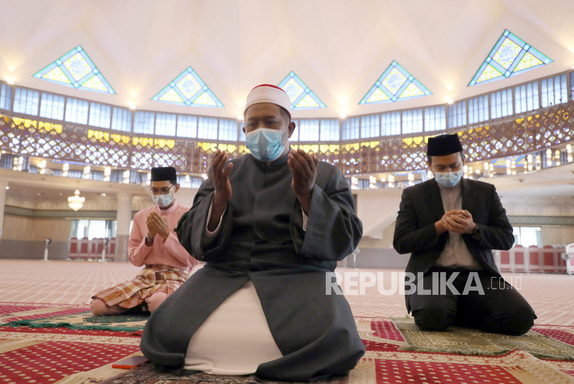 Umat Muslim mengenakan masker dan menerapkan jarak sosial berdoa di dalam Masjid Nasional, Kuala Lumpur, Malaysia, Jumat (15/5). Viral Kipas Angin Dijadikan Makmum, Ini Komentar Mufti Penang