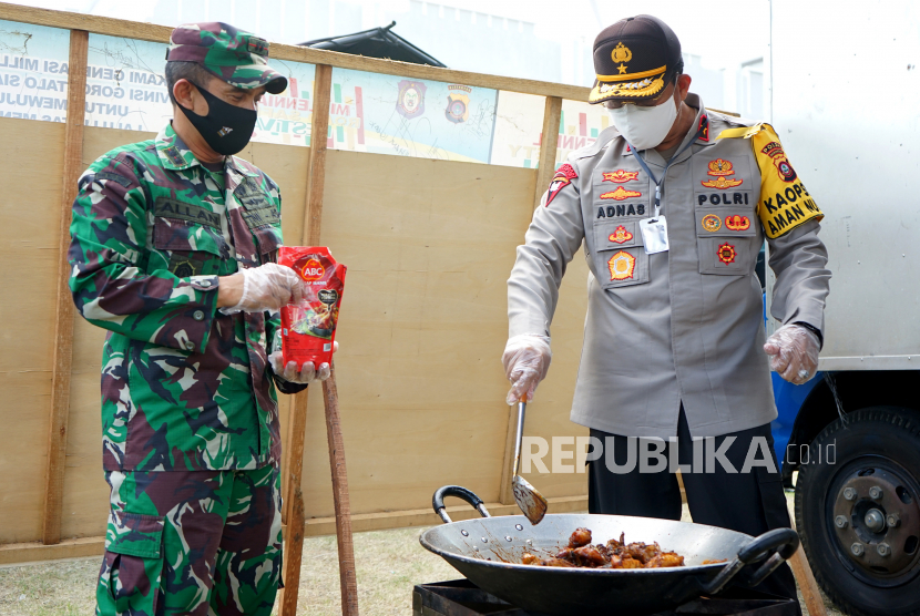 Kapolda Gorontalo Brigjen Pol Adnas (kanan) bersama Dandim 1304 Letkol Inf Allan Surya Lesmana (kiri) memasak ayam kecap untuk makanan berbuka puasa di Kota Gorontalo, Gorontalo, Jumat (8/5/2020). Polda Gorontalo bersama Kodim 1304 membuka dapur umum lapangan yang menyiapkan makanan buka puasa dan sahur bagi masyarakat kurang mampu terdampak pandemi COVID-19 di kabupaten dan kota di daerah tersebut