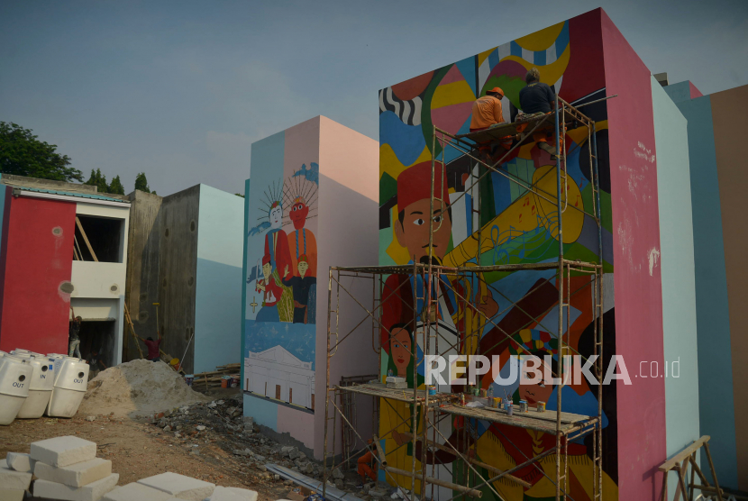 Petugas Penanganan Prasarana dan Sarana Umum (PPSU) menyelesaikan pembuatan mural di Kampung Gembira Gembrong, Jakarta, Selasa (13/9/2022). Walkot Jaktim sebut proses revitalisasi Kampung Gembrong akan segera selesai.