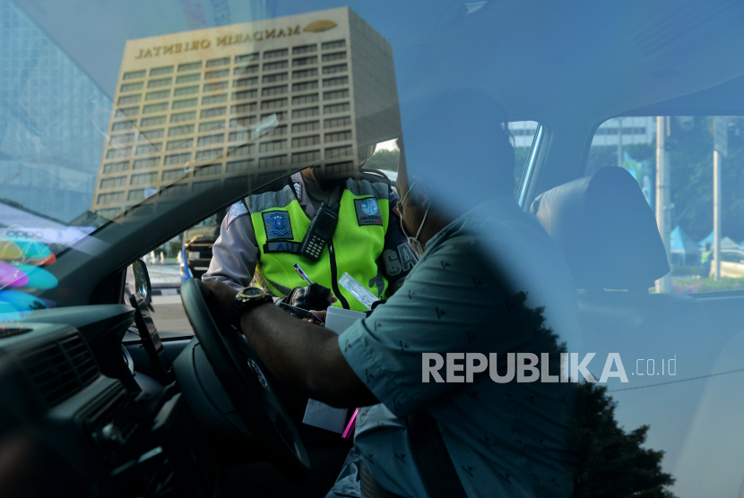 Petugas Kepolisian melakukan penindakan tilang manual terhadap pengemudi di kawasan Bundaran Hotel Indonesia, Jakarta, Selasa (16/5/2023). Anggaran Polri tahun ini Rp 99 triliun.
