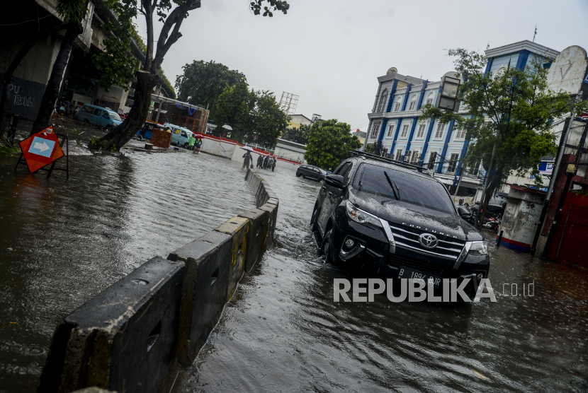 Sebuah mobil menerobos genangan air saat terjadi banjir di Jalan KH. Abdullah Syafei, Tebet, Jakarta, Kamis (18/2). Hujan deras yang mengguyur wilayah Jakarta menyebabkan aliran Kali Tebet meluap hingga merendam jalan protokol dengan ketinggian mencapai sepaha orang dewasa. Republika/Putra M. Akbar