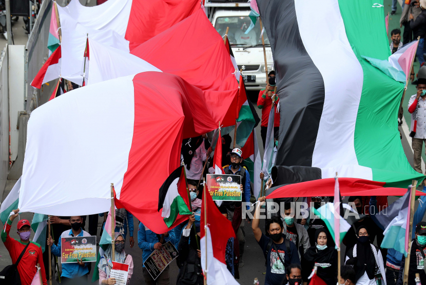  Orang-orang membawa bendera raksasa Indonesia dan Palestina 