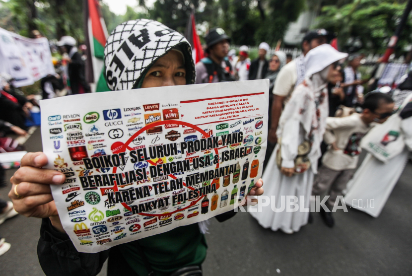 Sejumlah massa memperlihatkan poster produk Israel yang diboikot saat melakukan Aksi Bela Palestina di depan Kedutaan Besar Mesir, Jakarta, Ahad (19/5/2024). Pada aksi tersebut mereka menuntut pemerintah Mesir agar segera membuka pintu perbatasan Rafah untuk memperlancar penyaluran bantuan bagi warga Palestina di tengah gempuran dari Israel.