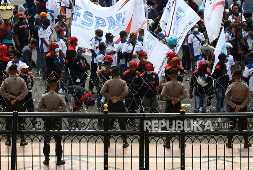 Polisi melakukan pengamanan unjuk rasa buruh di Surabaya, Jawa Timur. Buruh menolak kenaikan UMP 202 yang hanya naik 1,2 persen.
