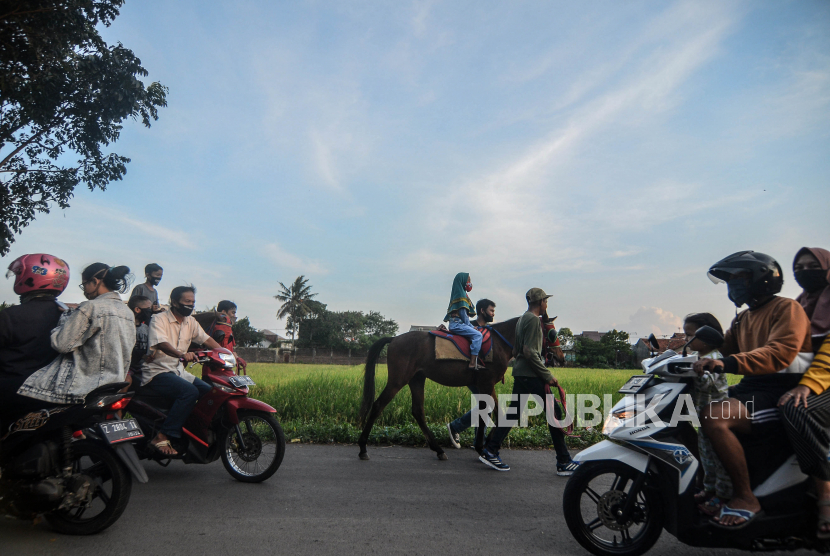 Anak-anak ngabuburit dengan menaiki kuda pacu yang disewakan di Cieunteung, Kota Tasikmalaya, Jawa Barat, Kamis (7/5). Jumlah kasus positif Covid-19 di Kota Tasikmalaya meningkat menjadi 37 orang pada 17 Mei.