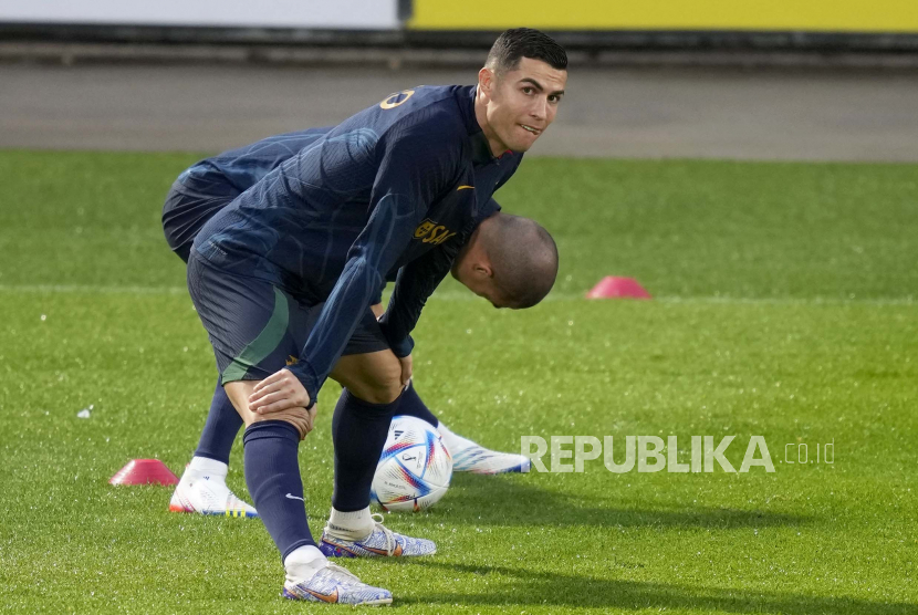 Cristiano Ronaldo melakukan peregangan dengan rekan setimnya Pepe, di latar belakang, selama sesi pelatihan timnas sepak bola Portugal di Oeiras, di luar Lisbon, Senin, 14 November 2022. Ronaldo berharap Portugal bisa jumpa Brasil di final Piala Dunia 2022.