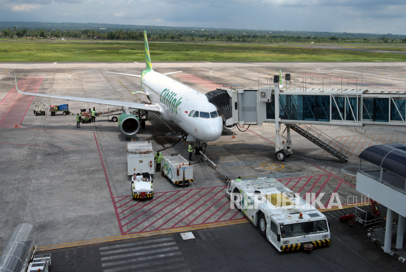 Pekerja melakukan bongkar muat koper dan barang bawaan penumpang pesawat maskapai Citilink.
