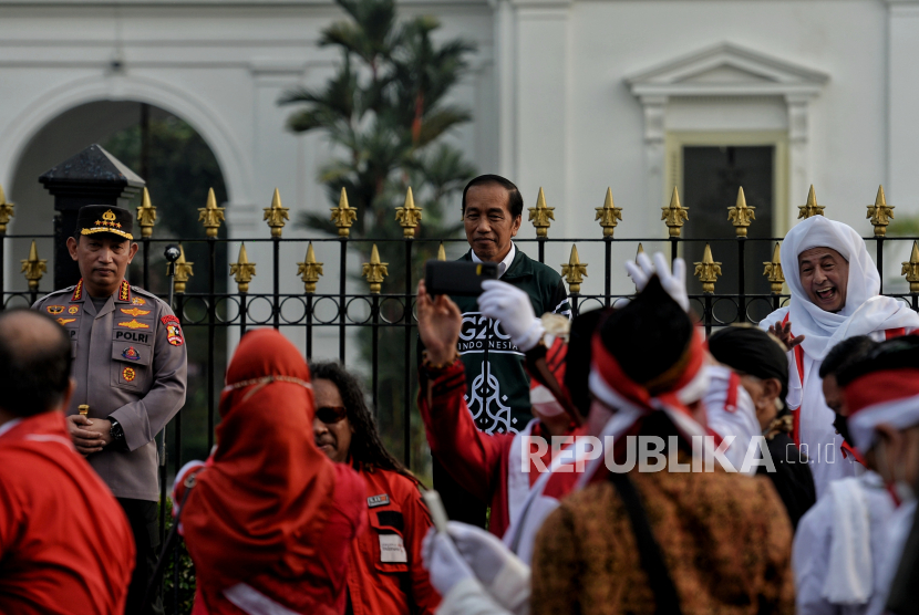 Presiden Joko Widodo (tengah) didampingi Kapolri Jenderal Listyo Sigit Prabowo (kiri) dan anggota Dewan Pertimbangan Presiden Habib Luthfi bin Yahya (kanan) saat melepas kirab bendera Merah Putih di kawasan Patung Kuda, Jakarta, Ahad (28/8/2022). Sebanyak 50.000 orang membentangkan bendera merah putih sepanjang 1.700 meter dari kawasan Monas hingga Bundaran HI. Kegiatan tersebut merupakan rangkaian dalam memperingati Hari Kemerdekaan Indonesia dengan tema 